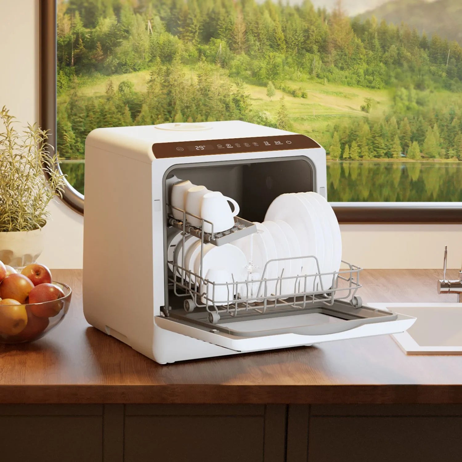 HAVA Bänkdiskmaskin från Go-clean.se med öppen lucka och fullastat diskställ på en träbänk, intill en skål med frukt och örtkruka, med utsikt mot sjö och skog genom ett fönster i bakgrunden.